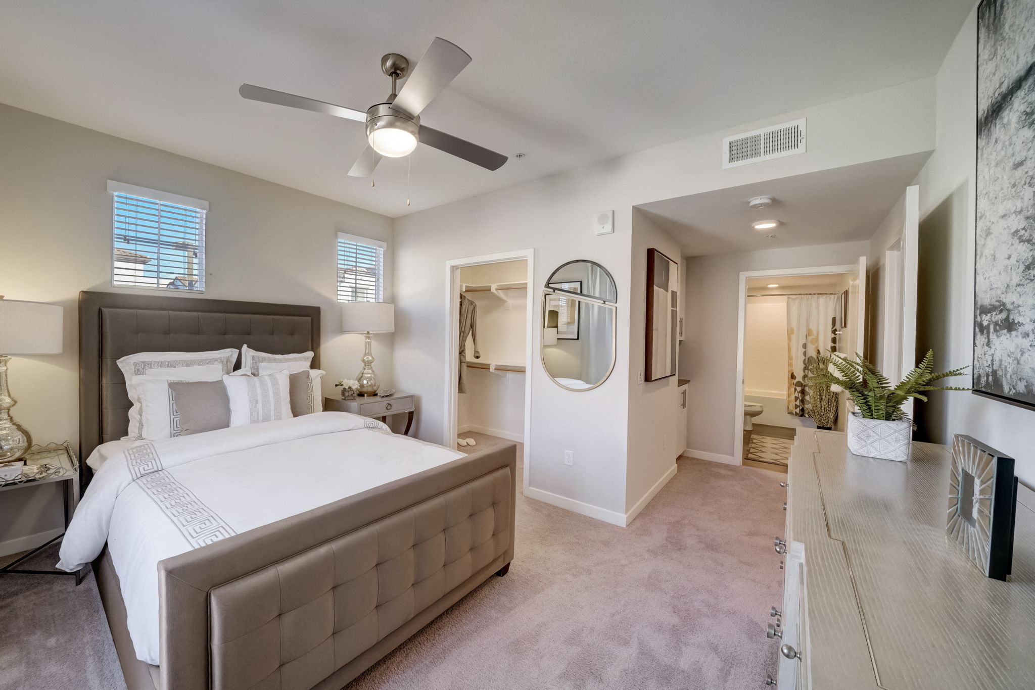 Cozy bedroom at Vistara Apartments with a large bed and ceiling fan, offering comfort and relaxation.